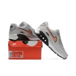 Nike Air Max 90 DZ5637-001 - グレーのスニーカー、ブラック&オレンジスウッシュ付き グレーのNike Air Max 90スニーカー、ブラックとオレンジのスウッシュが特徴的なデザイン。